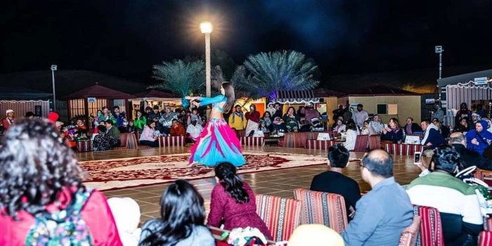 Dubai Comedy Festival crowd enjoying live comedy with Dubai desert safari dunes and camel ride experience